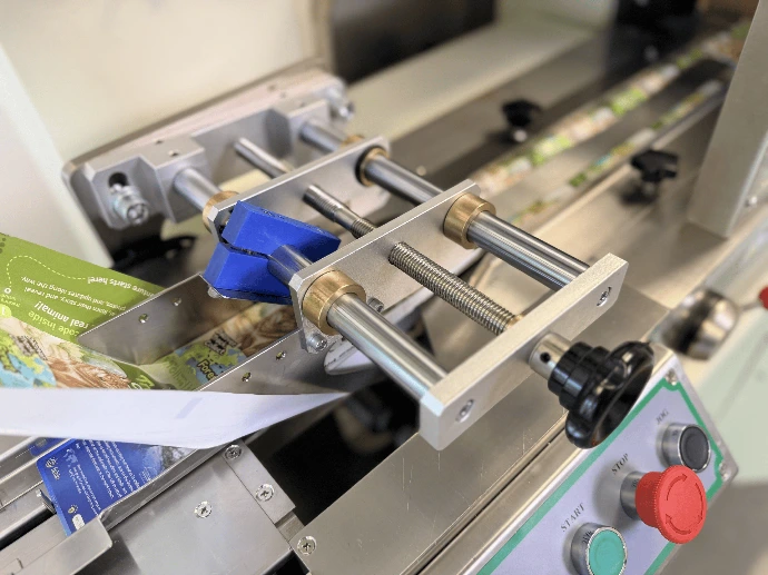 Automated trading card packaging line with film feed