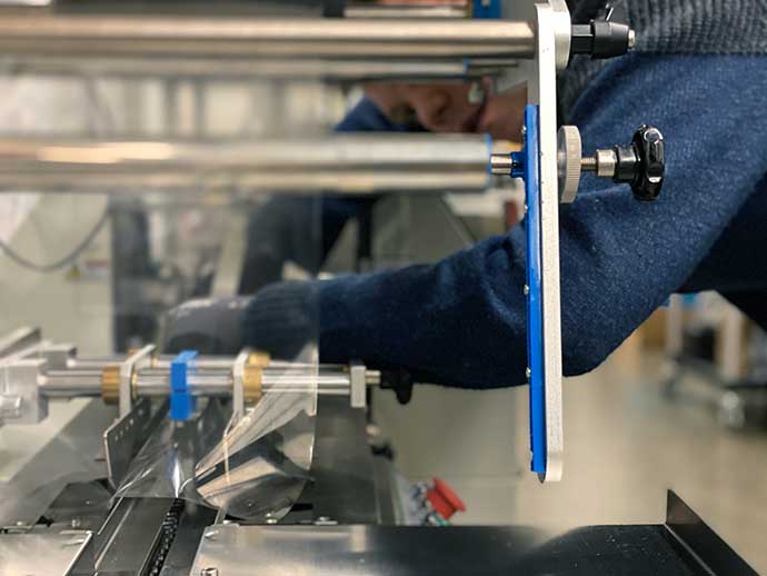 Bags Etc technician setting up film on a packaging machine
