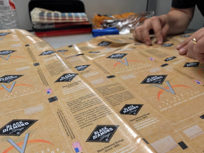 Reviewing printed Black Diamond packaging film on a worktable